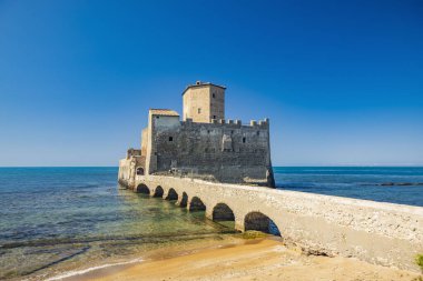 Nettuno 'daki Torre Astura doğa koruma alanı. Gözetleme kulesi ve antik Roma binalarının kalıntılarıyla birlikte denizdeki antik şato. Kaleyi sahile bağlayan taş bir köprü var..