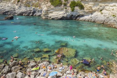 15 Ağustos 2023 - Santa Cesarea Terme, Salento, Puglia, İtalya. Porto Miggiano 'nun inanılmaz körfezi. Turist ve teknelerle dolu, berrak, mavi ve turkuaz denizde. Yüksek kayalıkların arasında küçük bir sahil var.