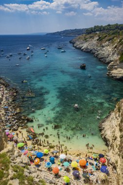 Porto Miggiano 'nun inanılmaz körfezi, Santa Cesarea Terme, Salento, Puglia, İtalya. Turist ve teknelerle dolu, berrak, mavi ve turkuaz denizde. Yüksek kayalıkların arasında küçük bir sahil var.