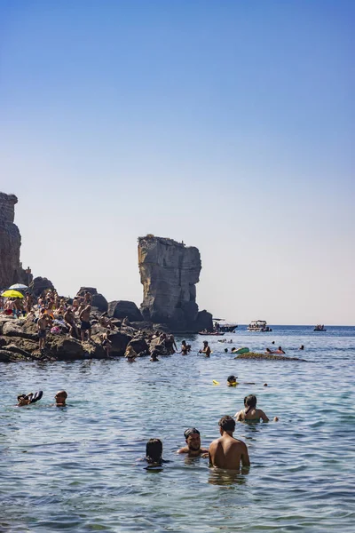 15 Ağustos 2023 - Santa Cesarea Terme, Salento, Puglia, İtalya. Porto Miggiano 'nun inanılmaz körfezi. Turistlerle, banyolarla ve teknelerle dolu, harika denizin tadını çıkarıyorlar, berrak, mavi ve turkuaz..