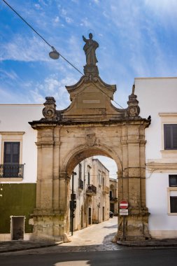 Agosto 20, 2023 - Galatina, Lecce, Puglia, İtalya. Salento 'daki antik bir köy. Porta San Pietro veya Porta Nuova. Büyük mermer kemerin üzerinde bir azizin heykeli var. Şehrin merkezine açılan bir kapı..