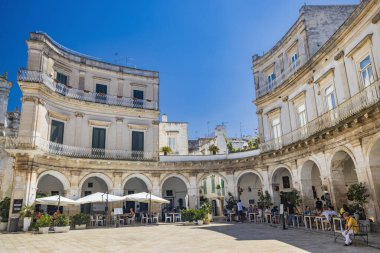 18 Ağustos 2023 - Martina Franca, Taranto, Puglia, İtalya. Barok mimarisi olan bir köy. Güzel Piazza Plebiscito, karakteristik girişi ile, turistlerle dolu. Yazın güneşli bir gün.