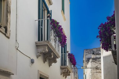 Martina Franca, Taranto, Puglia, İtalya. Barok mimarisi olan bir köy. Şehrin dar sokakları ve karakteristik balkonları olan binalar. Yazın güneşli bir günde mavi gökyüzü.