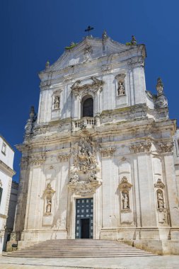 Martina Franca, Taranto, Puglia, İtalya. Barok mimarisi olan bir köy. Güzel Piazza Plebiscito 'daki San Martino Koleji Kilisesi. Yazın güneşli bir günde mavi gökyüzü.