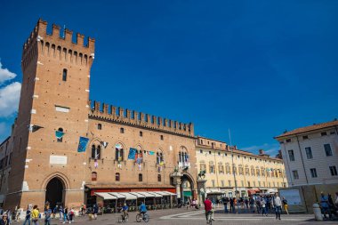 4 Haziran 2023 - Ferrara, Emilia Romagna, İtalya. Katedral meydanında, Este ailesinin bronz heykelleri bulunan Zafer Kulesi ve Belediye Sarayı. UNESCO Dünya Mirası Alanı.