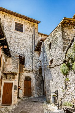 Castel di Tora, Rieti, Lazio, İtalya - 26 Mayıs 2024 - Turano Gölü 'ne bakan, yeşil dağlarla çevrili bir köy. Dar sokaklar ve taş ve tuğla evler.