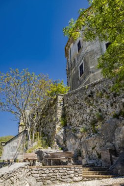 Castel di Tora, Rieti, Lazio, İtalya - 26 Mayıs 2024 - Turano Gölü 'ne bakan, yeşil dağlarla çevrili bir köy. Dar sokaklar ve taş ve tuğla evler.