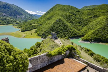 İtalya 'daki Castel di Tora, Rieti, Lazio, Rieti köyündeki Antuni Dağı' ndan Turano Gölü manzarası. Gölün üzerindeki yeşil dağlarla çevrili küçük inziva yeri. Yazın mavi gökyüzü.