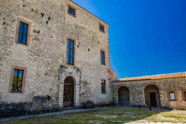 Antuni Dağı 'ndaki kale, Turano Gölü' ndeki Castel di Tora, Rieti, Lazio, İtalya yakınlarındaki köy. Issız köy, yeşil dağlarla çevrili gölün merkezinde duruyor..