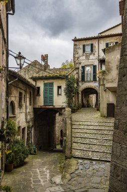 Melankolik ve yağmurlu bir bahar gününde eski ortaçağ köyü Sorano 'ya bir göz atalım. Grosseto, Toskana, İtalya 'da. Taş ve tuğla tuğlalardan yapılmış eski evler.