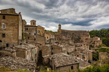 Melankolik ve yağmurlu bir bahar gününde eski ortaçağ köyü Sorano 'ya bir göz atalım. Grosseto, Toskana, İtalya 'da. Taş ve tuğla tuğlalardan yapılmış eski evler.