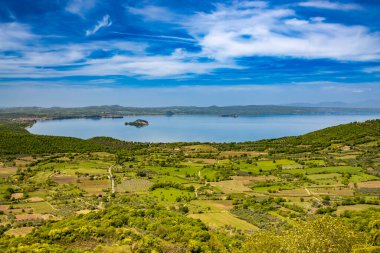 İtalya 'nın Viterbo kentindeki Montefiascone antik ortaçağ köyünün panoramik terasında görülen Bolsena Gölü' nün büyüleyici panoraması. Bir yaz akşamında ufukta sis var..