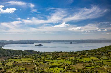 İtalya 'nın Viterbo kentindeki Montefiascone antik ortaçağ köyünün panoramik terasında görülen Bolsena Gölü' nün büyüleyici panoraması. Bir yaz akşamında ufukta sis var..
