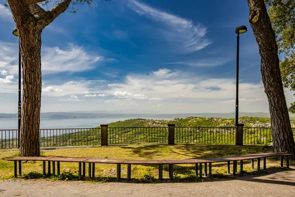 İtalya 'nın Viterbo kentindeki Montefiascone antik ortaçağ köyünün panoramik terasında görülen Bolsena Gölü' nün büyüleyici panoraması. Bir yaz akşamında ufukta sis var..