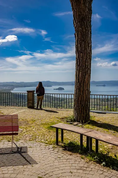 stock image The enchanting panorama of Lake Bolsena, seen from the panoramic terrace of the ancient medieval village of Montefiascone, Viterbo, Italy. Some tourists enjoy the view on a summer evening.