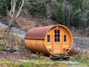 A private accommodation unit in the form of a large wooden barrel or a glamping bungalow in a barrel - the Calfeisental valley and in the UNESCO World Heritage Tectonic Arena Sardona, Switzerland / Schweiz clipart