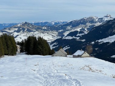 İsviçre çayırlarındaki yerli dağ kulübeleri ve ahşap ahırlar Alpstein dağ kütlesi Urnaesch 'in (ya da Urnasch) taze kar örtüsüyle kaplıdır.