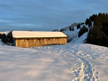 İsviçre çayırlarındaki yerli dağ kulübeleri ve ahşap ahırlar Alpstein dağ kütlesi Urnaesch 'in (ya da Urnasch) taze kar örtüsüyle kaplıdır.