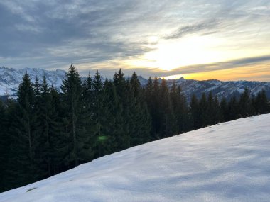 Obertoggenburg bölgesinde ve İsviçre Prealps, Urnaesch 'te (ya da Urnasch) kış bulutlarının ardında büyülü günbatımı ve utangaç güneş - Appenzell Innerrhoden Kantonu, İsviçre / Schweiz