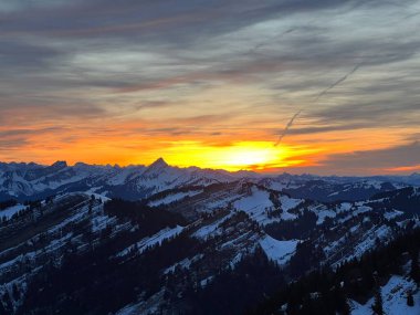 Obertoggenburg bölgesinde ve İsviçre Prealps, Urnaesch 'te (ya da Urnasch) kış bulutlarının ardında büyülü günbatımı ve utangaç güneş - Appenzell Innerrhoden Kantonu, İsviçre / Schweiz