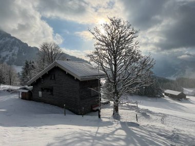 Indigenous alpine huts and wooden cattle stables in the Swiss Alps covered with fresh first snow over the Lake Walen or Lake Walenstadt (Walensee), Amden - Canton of St. Gallen, Switzerland / Schweiz