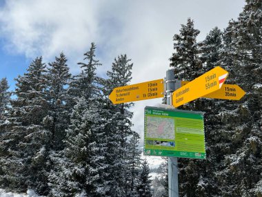 Hiking markings and orientation signs with signposts for navigating in the idyllic winter ambience over the Lake Walen or Lake Walenstadt (Walensee) and in the Swiss Alps, Amden - Switzerland / Schweiz