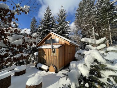 Indigenous alpine huts and wooden cattle stables in the Swiss Alps covered with fresh first snow over the Lake Walen or Lake Walenstadt (Walensee), Amden - Canton of St. Gallen, Switzerland / Schweiz