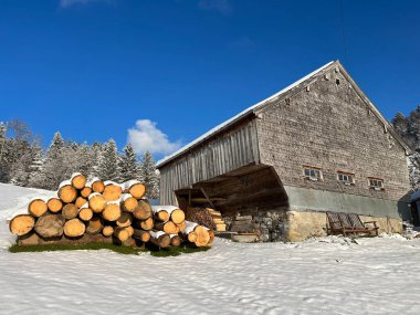 Indigenous alpine huts and wooden cattle stables in the Swiss Alps covered with fresh first snow over the Lake Walen or Lake Walenstadt (Walensee), Amden - Canton of St. Gallen, Switzerland / Schweiz