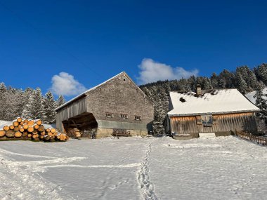 Indigenous alpine huts and wooden cattle stables in the Swiss Alps covered with fresh first snow over the Lake Walen or Lake Walenstadt (Walensee), Amden - Canton of St. Gallen, Switzerland / Schweiz
