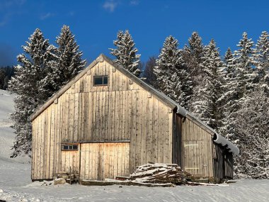 Indigenous alpine huts and wooden cattle stables in the Swiss Alps covered with fresh first snow over the Lake Walen or Lake Walenstadt (Walensee), Amden - Canton of St. Gallen, Switzerland / Schweiz