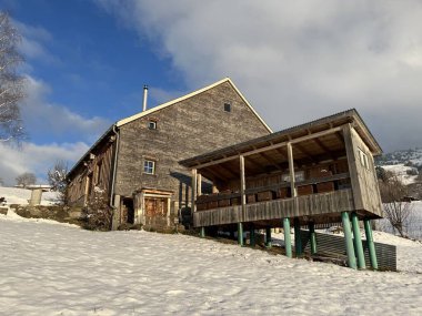 Indigenous alpine huts and wooden cattle stables in the Swiss Alps covered with fresh first snow over the Lake Walen or Lake Walenstadt (Walensee), Amden - Canton of St. Gallen, Switzerland / Schweiz