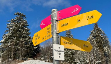 Hiking markings and orientation signs with signposts for navigating in the idyllic winter ambience over the Lake Walen or Lake Walenstadt (Walensee) and in the Swiss Alps, Amden - Switzerland / Schweiz