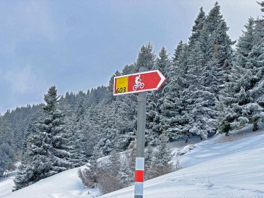 Hiking markings and orientation signs with signposts for navigating in the idyllic winter ambience above the tourist resorts of Valbella and Lenzerheide in the Swiss Alps - Canton of Grisons, Switzerland / Schweiz