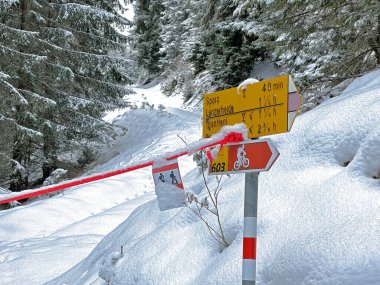 Hiking markings and orientation signs with signposts for navigating in the idyllic winter ambience above the tourist resorts of Valbella and Lenzerheide in the Swiss Alps - Canton of Grisons, Switzerland / Schweiz
