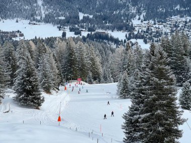 Snowboard and ski trails or alpine trails for winter sports above the tourist resorts of Valbella and Lenzerheide in the Swiss Alps - Canton of Grisons, Switzerland / Schweiz