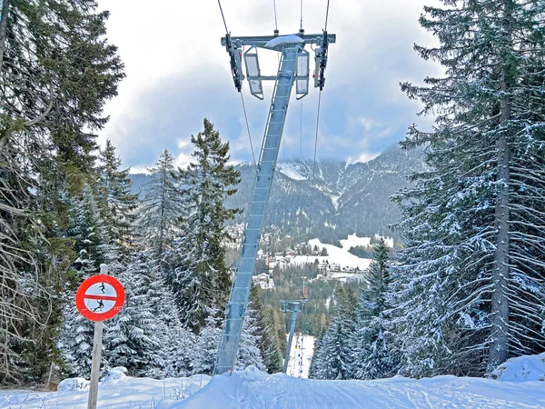 T-bar ski lift (Schlepplift mit T-Buegel-Anker) on the snowy slopes of the Swiss alpine winter resorts of Valbella and Lenzerheide in the Swiss Alps - Canton of Grisons, Switzerland (Schweiz)