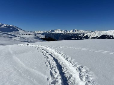 Wonderful winter hiking trails and traces in the fresh alpine snow cover of the Swiss Alps and over the tourist resort of Arosa - Canton of Grisons, Switzerland (Schweiz)