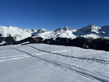 Wonderful winter hiking trails and traces in the fresh alpine snow cover of the Swiss Alps and over the tourist resort of Arosa - Canton of Grisons, Switzerland (Schweiz)