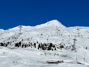 Beautiful sunlit and snow-capped alpine peaks above the Swiss tourist sports-recreational winter resort of Arosa - Canton of Grisons, Switzerland (Schweiz)