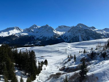 Beautiful sunlit and snow-capped alpine peaks above the Swiss tourist sports-recreational winter resort of Arosa - Canton of Grisons, Switzerland (Schweiz)