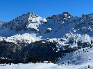 Beautiful sunlit and snow-capped alpine peaks above the Swiss tourist sports-recreational winter resort of Arosa - Canton of Grisons, Switzerland (Schweiz)