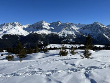 Beautiful sunlit and snow-capped alpine peaks above the Swiss tourist sports-recreational winter resort of Arosa - Canton of Grisons, Switzerland (Schweiz)