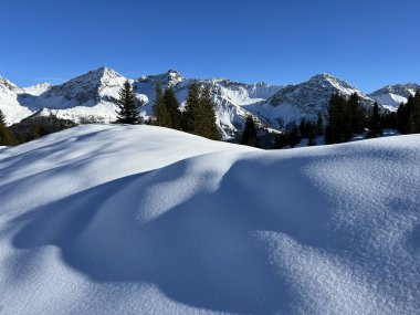 Beautiful sunlit and snow-capped alpine peaks above the Swiss tourist sports-recreational winter resort of Arosa - Canton of Grisons, Switzerland (Schweiz)