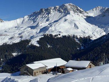 Old traditional swiss rural architecture and alpine livestock farms in the winter ambience of the alpine Swiss tourist resort Arosa - Canton of Grisons, Switzerland (Schweiz)