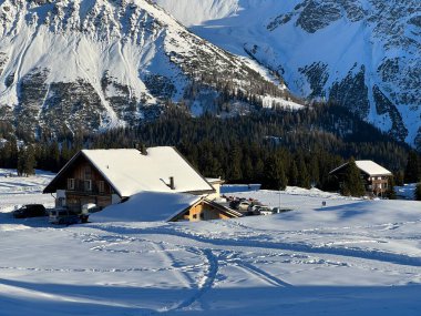 Old traditional swiss rural architecture and alpine livestock farms in the winter ambience of the alpine Swiss tourist resort Arosa - Canton of Grisons, Switzerland (Schweiz)