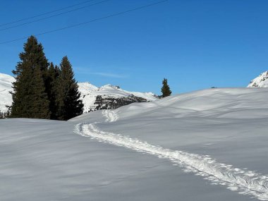 Wonderful winter hiking trails and traces in the fresh alpine snow cover of the Swiss Alps and over the tourist resort of Arosa - Canton of Grisons, Switzerland (Schweiz)