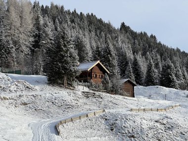 Old traditional swiss rural architecture and alpine livestock farms in the winter ambience of the alpine Swiss tourist resort Arosa - Canton of Grisons, Switzerland (Schweiz)