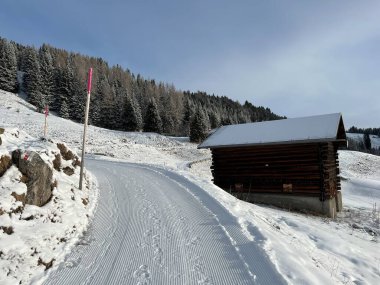 Old traditional swiss rural architecture and alpine livestock farms in the winter ambience of the alpine Swiss tourist resort Arosa - Canton of Grisons, Switzerland (Schweiz)