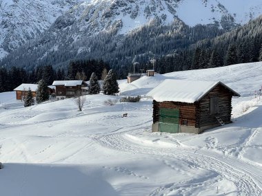 Old traditional swiss rural architecture and alpine livestock farms in the winter ambience of the alpine Swiss tourist resort Arosa - Canton of Grisons, Switzerland (Schweiz)