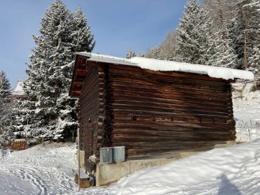 Old traditional swiss rural architecture and alpine livestock farms in the winter ambience of the alpine Swiss tourist resort Arosa - Canton of Grisons, Switzerland (Schweiz)